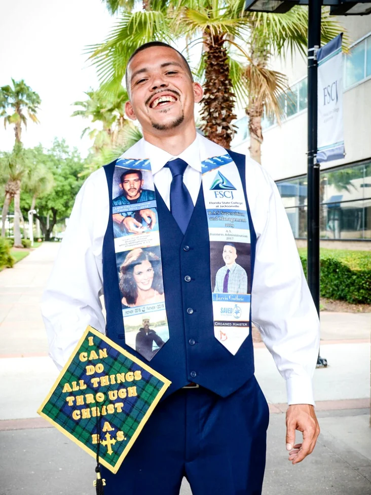 Jarvis Guthrie, founder of Saved By Grace House, at his Florida State College at Jacksonville graduation wearing a cap reading "I can do all things through Christ"